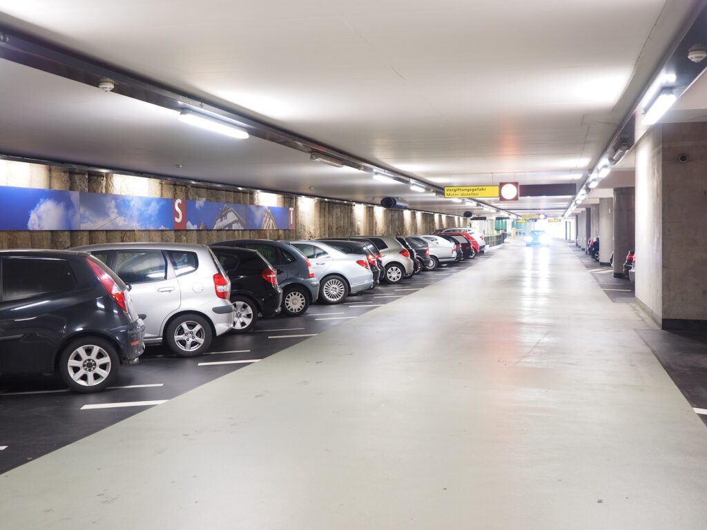 Tiefgaragenreinigung Berlin &ndash; helle Tiefgarage mit geparkten Autos und gl&auml;nzendem Boden
