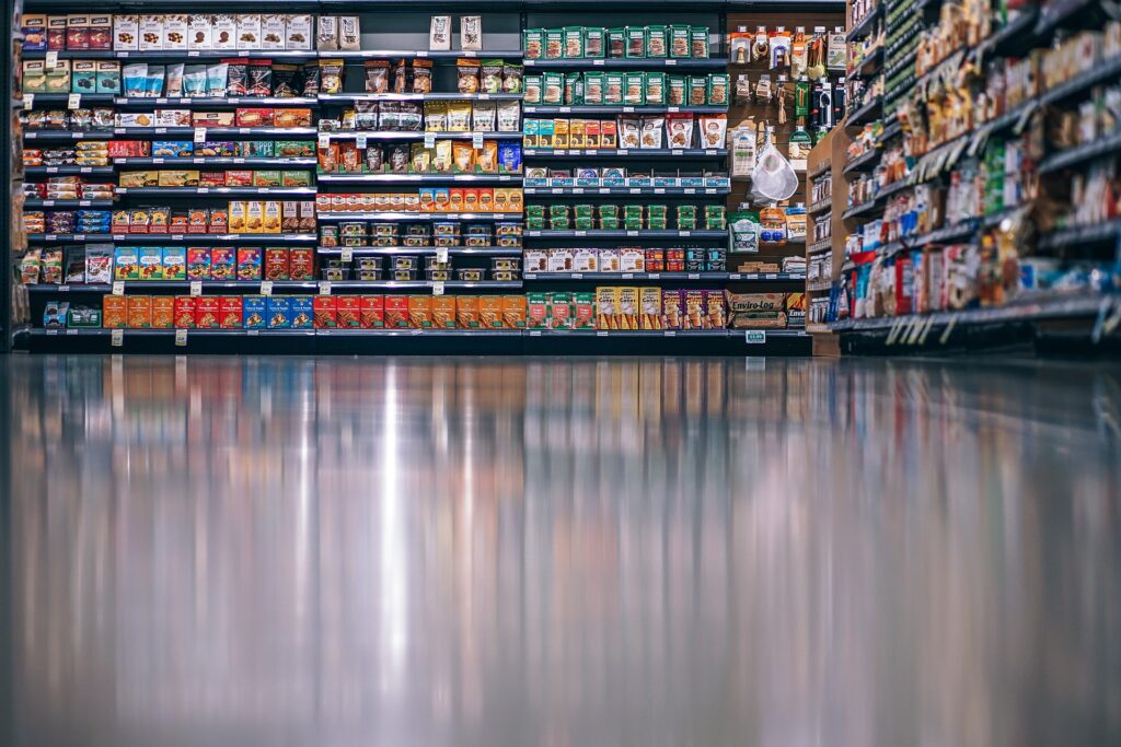 Ladenreinigung Berlin &ndash; Supermarktgang mit vollen Regalen und spiegelndem Boden