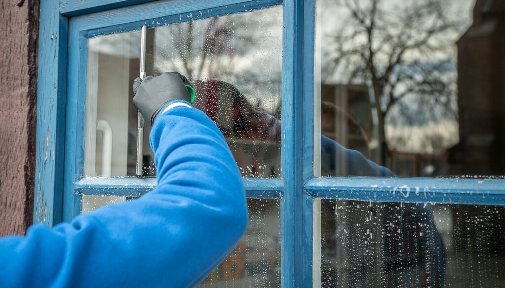 Glasreinigung Berlin Glasfassade Gewerbe 1024x584 Fensterputzer in Berlin reinigt ein Fenster mit Holzrahmen von Hand