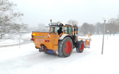 Hausmeisterservice Berlin &ndash; Traktor mit R&auml;umschild auf einer verschneiten Zufahrt